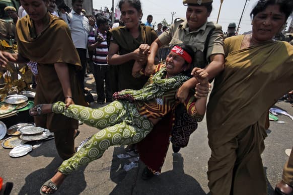 Policewomen detain an activist participating in