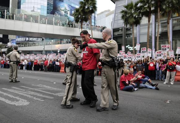 Las Vegas Metropolitan Police officers lead away a protestor during a civil disobedience demonstration by Culinary Union workers outside the Cosmopolitan Hotel-Casino in Las Vegas.