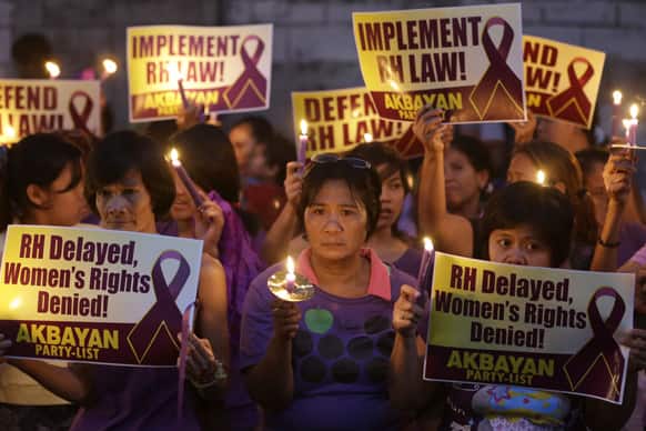 Protesters display placards and lighted candles during a rally at the Philippine Supreme Court in Manila, Philippines to protest the highest court`s issuance of a 120-day status quo ante order or a four-month delay of the implementation of the Reproductive Health Law.