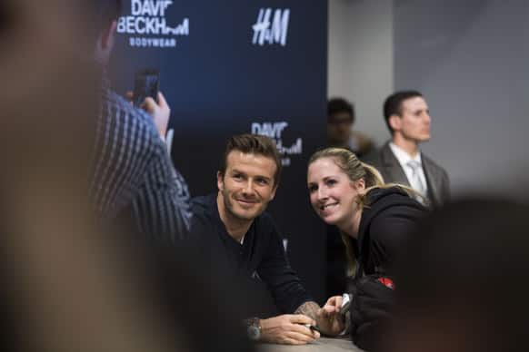 British soccer player David Beckham poses with a woman during an autograph session in a clothing chain shop in Berlin, Germany. Beckham signed pieces of his body wear collection for selected clients.