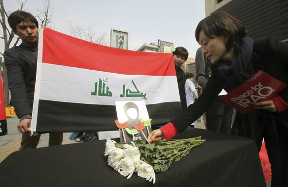 A protester places a paper pigeon to mourn Iraqis who were killed in the US-led invasion of Iraq during a rally on the eve of the tenth anniversary of the war near the US Embassy in Seoul, South Korea.