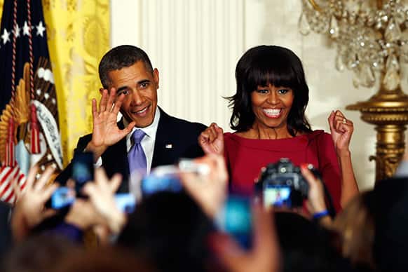 President Barack Obama and first lady Michelle Obama take the stage at a Women`s History Month reception in the East Room at the White House in Washington.