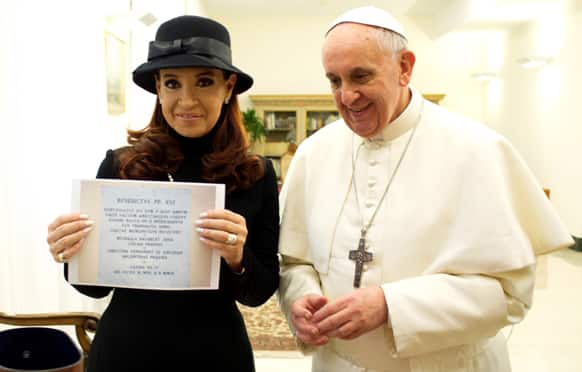 Pope Francis stands by Argentine President Cristina Fernandez showing a picture of a marble plaque commemorating the 1984 peace and friendship treaty between Argentina and Chile as they meet at the Pope`s temporary apartments in the Santa Marta hotel at the Vatican.