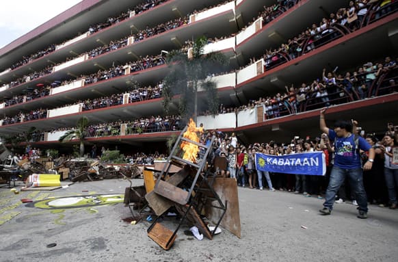 Students from the Polytechnic University, burn old chairs and computer monitors during a protest in support of Kristel Tejada, a 16-year-old freshman of the university, who committed suicide three days ago after being forced to take a leave-of-absence for her failure to pay her tuition, in Manila.
