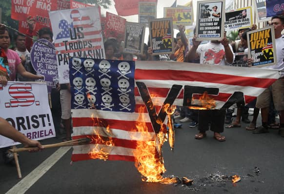 Filipino protesters burn a mock US flag during a rally near the US Embassy in Manila, Philippines.