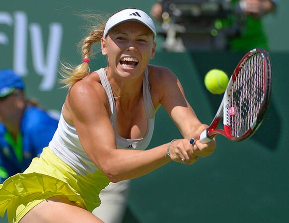 Caroline Wozniacki, of Denmark, makes a return against Maria Sharapova, of Russia, during their match at the BNP Paribas Open tennis tournament.