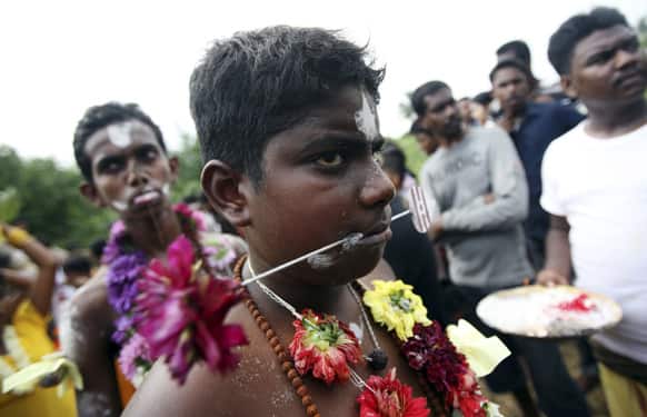 A worshipper has his cheeks pierced during the Tamil Hindu festival of Panguni Uthiram in Langkat, North Sumatra, Indonesia.