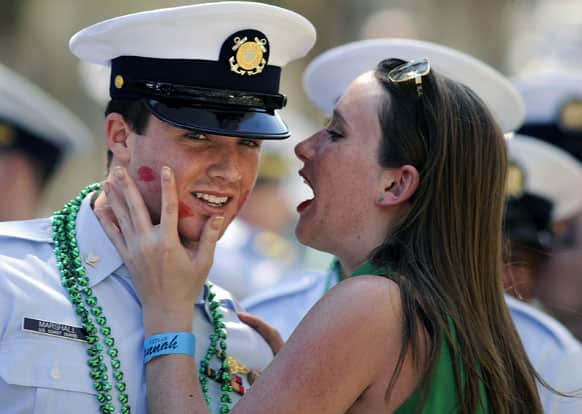 US Coast Guard Petty Officer 3rd Class Tanner Marshall is kissed by a woman during a St. Patrick’s Day parade, in Savannah, Ga. St.
