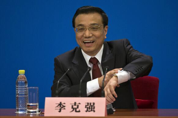 Newly-named Chinese Premier Li Keqiang gestures with his watch while suggesting to end a press conference after the closing ceremony of the National People`s Congress held in Beijing`s Great Hall of the People, China.
