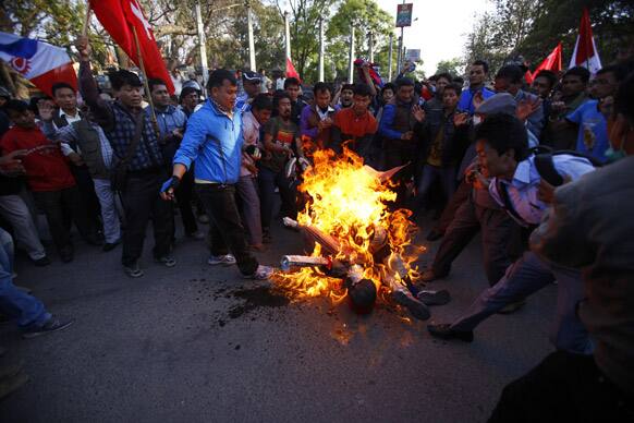 Members of a splinter faction of the Unified Communist Party of Nepal Maoist shout slogans as they burn an effigy of Prime Minister Khilraj Regmi in Katmandu.