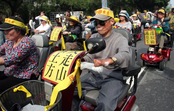 Taiwanese leprosy victims drive their battery-operated vehicles during a protest against the government`s plan to demolish leprosy victims sanatorium in Taipei, Taiwan.