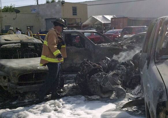 A Fort Lauderdale Fire Rescue worker checks a part of the Piper PA31 twin-engine that crashed shortly after takeoff from Fort Lauderdale Executive Airport into a parking lot east of the Airport in Fort Lauderdale, Fla.