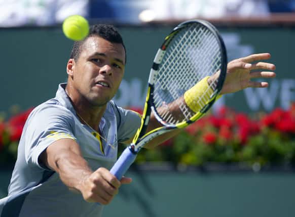 Jo-Wilfried Tsonga, of France, returns a shot to Novak Djokovic, of Serbia, at the BNP Paribas Open tennis tournament.