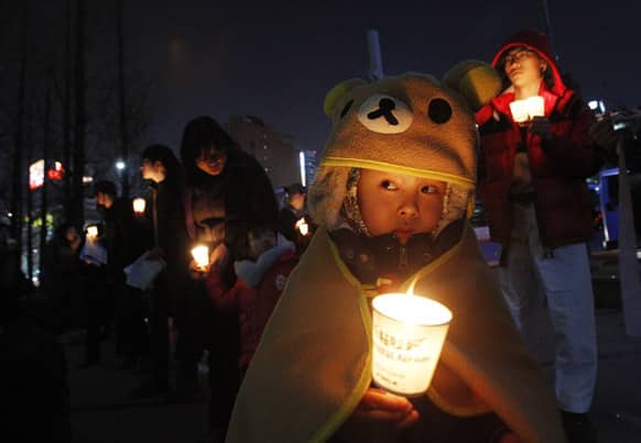 A South Korean child holds a candle light during a rally denouncing the annual joint military exercises, dubbed Key Resolve and Foal Eagle, South Korea and the United States joint military exercise, in Seoul, South Korea.