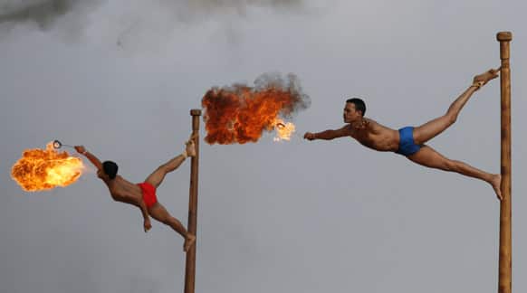 Indian army soldiers spit fire as they perform the mallakhamb, a traditional Indian gymnastic sport, during a display of skills at Officers Training Academy in Chennai.