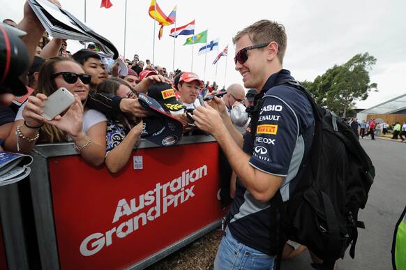 Red Bull driver Sebastian Vettel of Germany signs his autographs ahead of the first practice session for the Australian Formula One Grand Prix at Albert Park in Melbourne, Australia.