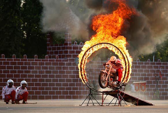 An Indian army soldier rides a bike through a ring of fire during a display of skills at Officers Training Academy in Chennai.