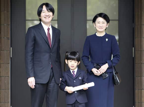 Prince Hisahito holding a certificate of graduation, accompanied by his father Prince Akishino, and mother Princess Kiko poses for photos after he attended his graduation ceremony at Ochanomizu University affiliated kindergarten in Tokyo.