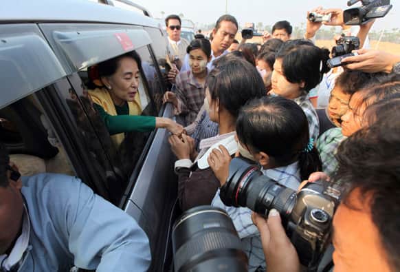 Myanmar opposition leader Aung San Suu Kyi greets villagers at a village near the Letpadaung copper mine project area in Monywa, 760 kilometers (450 miles) north of Yangon, Myanmar.