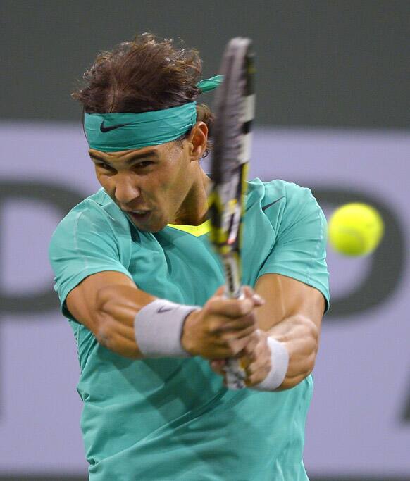 Rafael Nadal, of Spain, returns a shot to Ernests Gulbis, of Latvia, during their match at the BNP Paribas Open tennis tournament in Indian Wells, Calif.