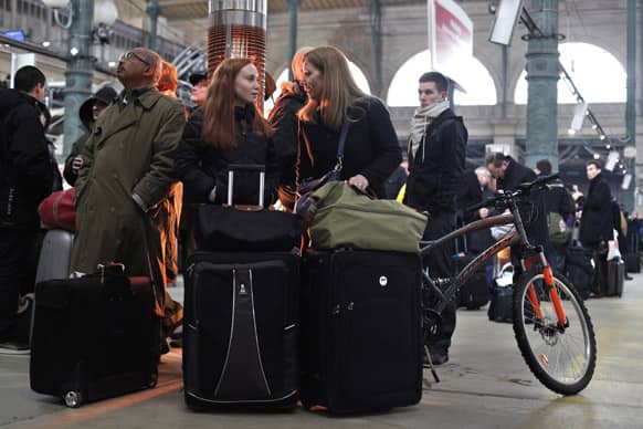 Passengers talk as they wait at Gare du Nord station in Paris. Snow and freezing temperatures continue to cause travel chaos Wednesday as some hundreds of flights in Europe have been canceled, trains are disrupted and some roads impassable.