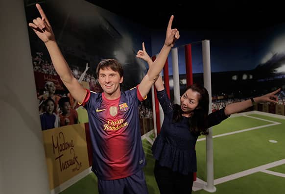A visitor poses with the wax figure of Lionel Messi at the Madame Tussauds exhibition in Tokyo.