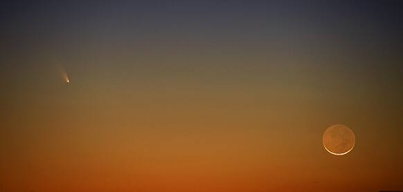 Comet PanSTARRS (left) appears to the left of a slim crescent moon in Tuesday March 12, 2013 evening`s western sky. The comet rounded the sun on Sunday and is now visible low in the western evening sky. This picture was made shortly after sunset near Harrells, NC.