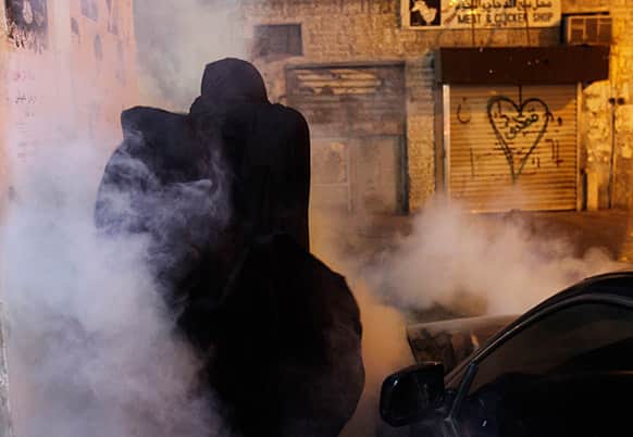 A Bahraini anti-government protester reacts to tear gas fired by riot police during a protest in Sanabis, Bahrain.