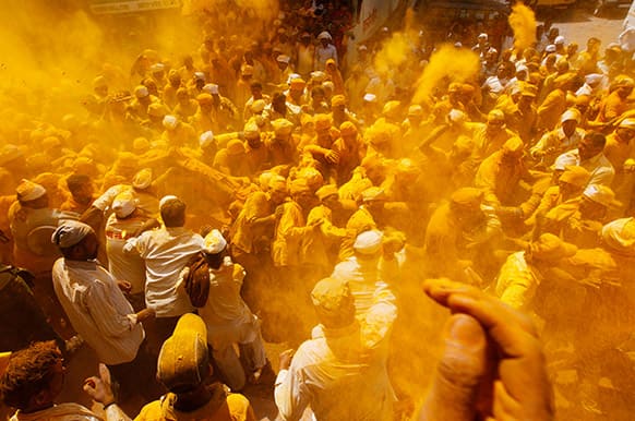 Devotees throw turmeric powder as an offering to the shepherd god Khandoba on `Somavati Amavasya` at the Jejuri temple in Pune district, Maharashtra.