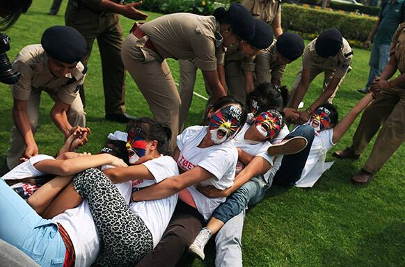 Policewomen try to break a human chain formed by exiled Tibetan women during a protest to mark the anniversary of a failed 1959 uprising against Chinese rule outside the Chinese Embassy in New Delhi.