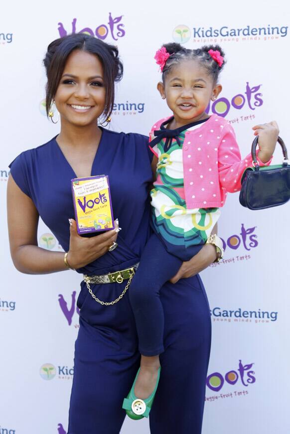 Christina Milian and daughter Violet smile for the camera while posing with Voots Veggie-Fruit tarts, a children`s supplement at the Voots `Get Kids Growing` Garden Workshop, at the Americana at Brand in Glendale, California.