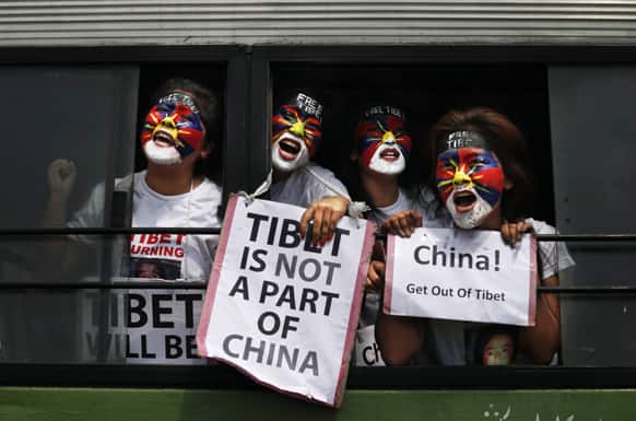 Exiled Tibetan women with their faces painted in the colors of a Tibetan flag shout slogans from inside a bus after they were detained during a protest to mark the anniversary of a failed 1959 uprising against Chinese rule outside the Chinese Embassy in New Delhi.