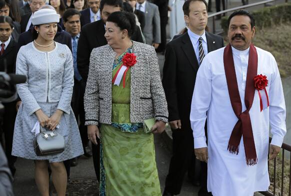 Sri Lankan President Mahinda Rajapaksa, right, walks with his wife Shiranthi Rajapaksa, center, and Japanese Princess Tsuguko while visiting the Tama Zoological Park in Tama, on the outskirts of Tokyo.
