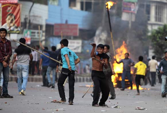 Bangladesh’s opposition activists burn a street vendor`s cart as they clash with police during their protest in Dhaka.