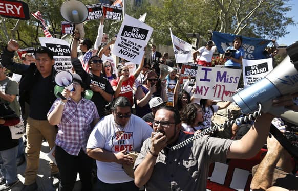 Dozens of immigration rights supporters chant during a Puente Movement event March Against Deportation, Family Separation, and Workplace Raids in front of Montgomery County Attorney Bill Montgomery`s office in Phoenix.