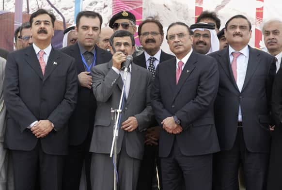 Iranian President Mahmoud Ahmadinejad, talks on a hand-held radio to order the official start of construction on a pipeline to transfer natural gas from Iran to Pakistan, as his Pakistani counterpart Asif Ali Zardari, center right, looks on, in Chabahar, southeastern Iran.