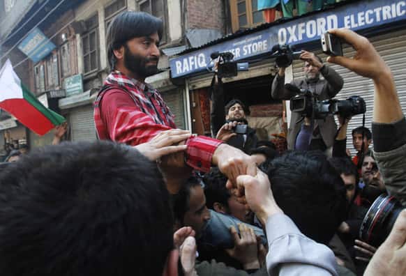 Jammu Kashmir Liberation Front Chairman Yasin Malik shakes hand with his supporters as he arrives in Srinagar, India. Malik who returned from Pakistan was put under house arrest Sunday.