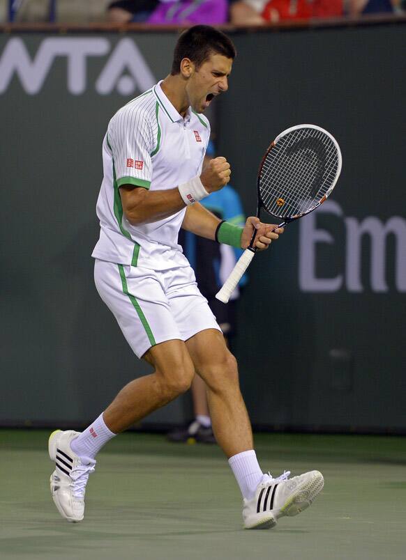 Novak Djokovic, of Serbia, celebrates after winning a game over Fabio Fognini, of Italy, during their match at the BNP Paribas Open tennis tournament.