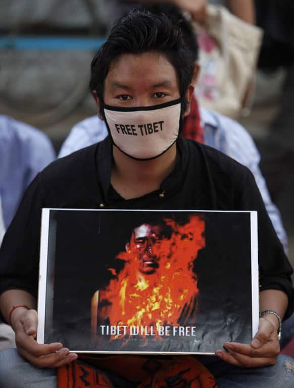 An exile Tibetan holds a poster during a sit-in protest in Hyderabad, India, as Tibetans mark the anniversary of a failed 1959 uprising against Chinese rule.