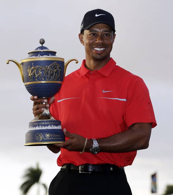 Tiger Woods holds the Gene Sarazen Cup for winning the Cadillac Championship golf tournament in Doral, Fla.