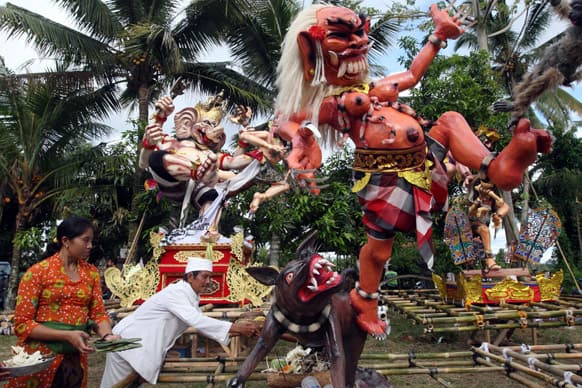 A Balinese priest puts an offering at