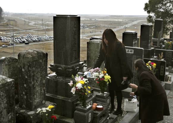 Mitsuko Ota, right, and her daughter Minami offer prayers for the victims of the March 11, 2011 earthquake and tsunami at their family`s grave, a day before the second anniversary of the disaster, in Rikuzentakata, Iwate Prefecture, northern Japan.