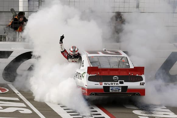 Sam Hornish Jr. waves to fans as he hangs out his window while doing a burnout after winning the NASCAR Nationwide Series auto race in Las Vegas.