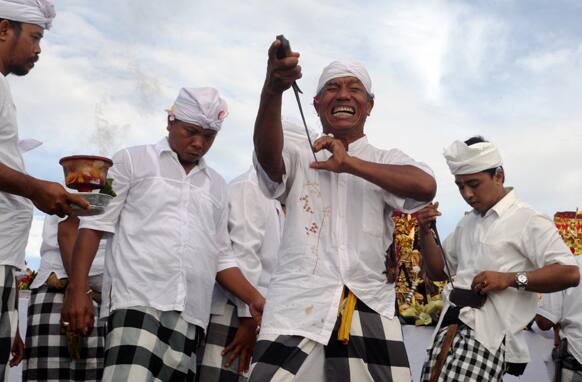 Balinese men are at the state of trance as they point