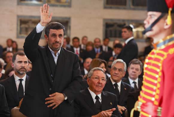 Iran`s President Mahmoud Ahmadinejad, salutes as he satnds next to Spain`s Crown Prince and Cuba`s President Raul Castro, during the funeral ceremony of late Venezuela`s President Hugo Chavez at the military academy in Caracas, Venezuela.