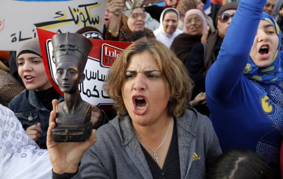 An Egyptian woman raises a statue of pharaonic Queen Hatshepsut, the only woman that ruled Egypt, as she shouts slogans during a demonstration in Cairo.