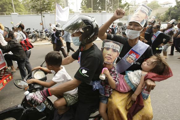 A Cambodian family, wearing a portrait of detained Yoam Bopha, a Boeung Kak lake villager, takes part in a rally to mark the World Women`s Day, in Phnom Penh, Cambodia.