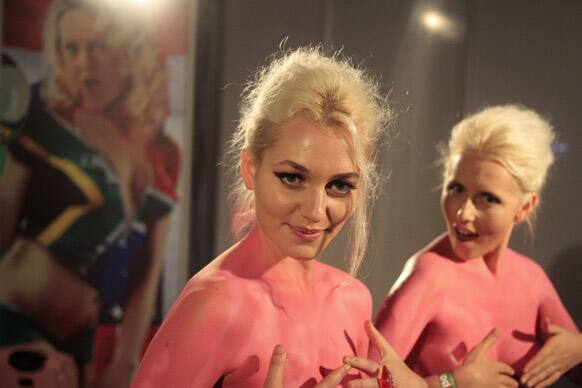 Artist known as the Soap Girls, react to the camera as they are spray painted with body paint during the yearly Sexpo, expo taking place in Cape Town , South Africa.