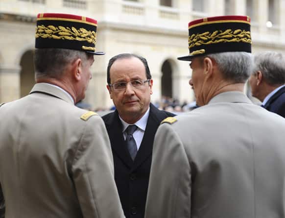 French President Francois Hollande is welcomed by military officials as he arrives to an homage ceremony for Stephane Hessel in Paris.