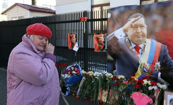 Belarusian woman mourns in front of a poster with the image of the late Venezuelan President Hugo Chavez inside Venezuela`s embassy in Minsk, Belarus.